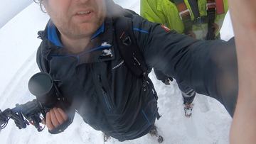 Selfie mit Kamera im Schnee, im Hintergrund Ski-Ausrüstung